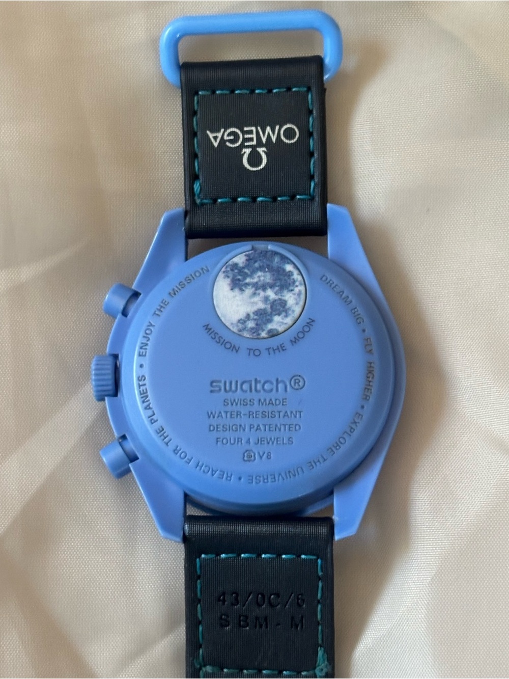 Swatch light blue chronograph with black strap and teal stitching